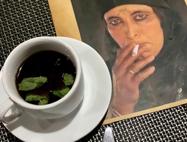 A cup of Mint tea and the pictureof a female beduoin smoking