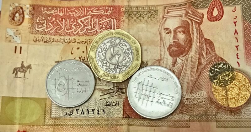 Banknote of 5JOD with coins of 5, 10 and 50 piastres