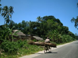 Man on a bicycle riding on hte left side of the road in Tanzania